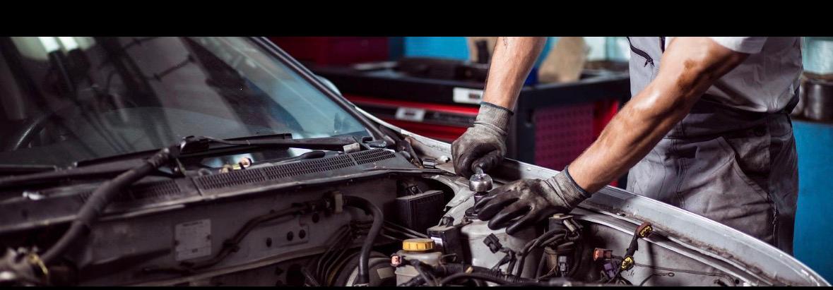 Mécanicien travaillant dans un garage pendant qu'un agent IA gère les appels